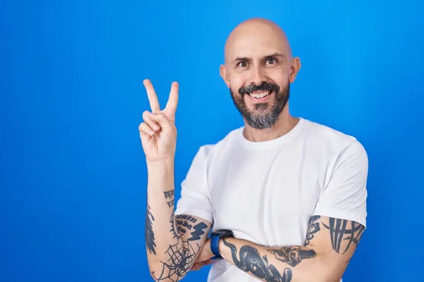 Spaanse Man Met Tattoos Die Een Blauwe Achtergrond Staan Glimlachen — Stockfoto