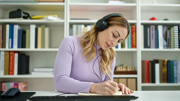 Young Beautiful Hispanic Woman Student Using Computer Writing Notebook Library — ストック写真