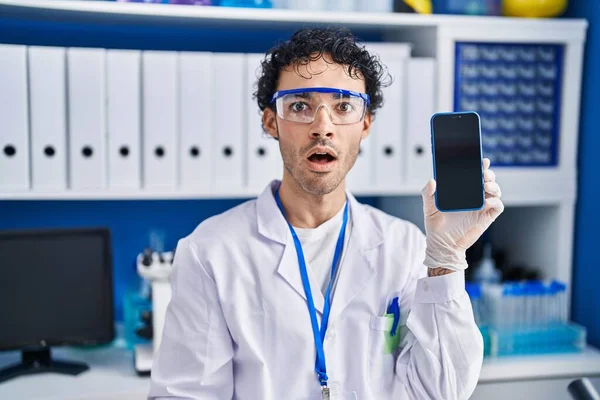 Латиноамериканец Работающий Научной Лаборатории Показывает Экран Смартфона Испуганным Изумленным Открытого — стоковое фото