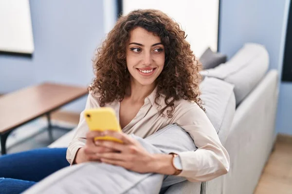 Jonge Spaanse Vrouw Met Behulp Van Smartphone Zitten Bank Thuis — Stockfoto