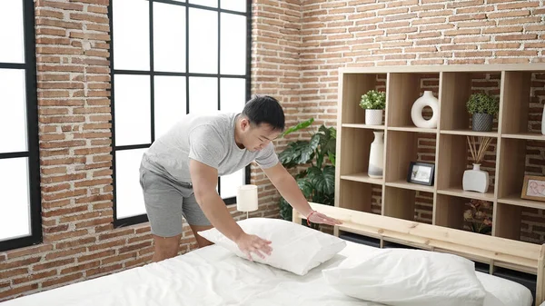 Genç Çinli adam yatak odasında yatar.