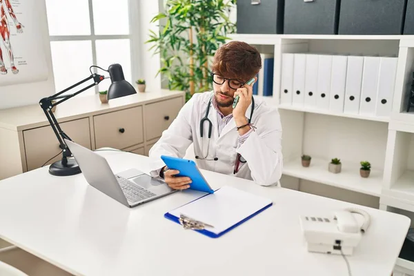 Young Arab Man Wearing Doctor Uniform Talking Smartphone Using Touchpad — Stock Photo, Image