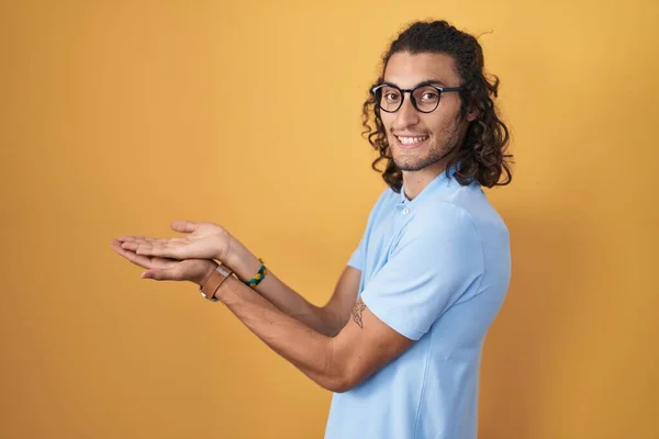 Young Hispanic Man Standing Yellow Background Pointing Aside Hands Open — Stock Photo, Image