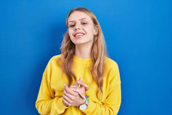 Young Caucasian Woman Standing Blue Background Hands Together Crossed Fingers — Stockfoto