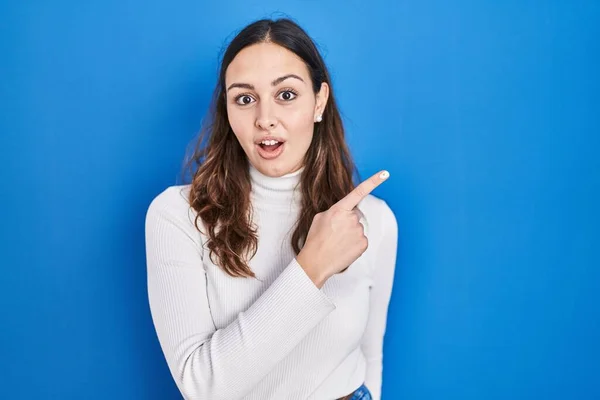 Young Hispanic Woman Standing Blue Background Surprised Pointing Finger Side — Stock Photo, Image