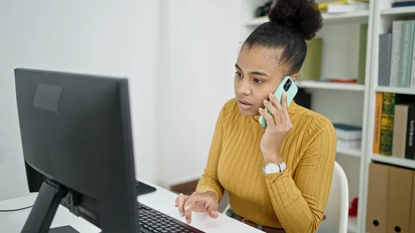 図書館で電話で話すコンピュータを使ってアフリカ系アメリカ人の若い女性の学生 — ストック写真