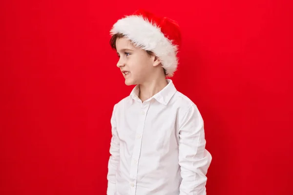 Little Caucasian Boy Wearing Christmas Hat Red Background Looking Side — Stock Photo, Image