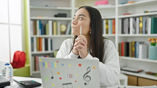 아름다운 히스패닉 노트북을 사용하여 대학교 교실에서 스러운 표정으로 공부하는 — 스톡 사진
