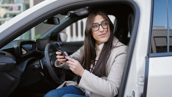 Young Beautiful Hispanic Woman Using Smartphone Sitting Car Street — Foto de Stock
