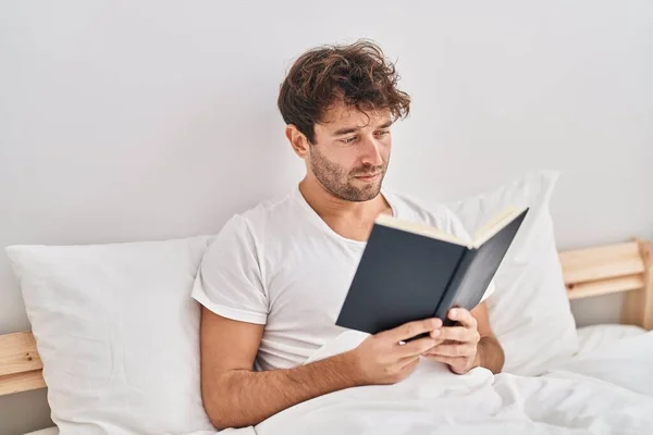 Young Man Reading Book Sitting Bed Bedroom — Stock Photo, Image