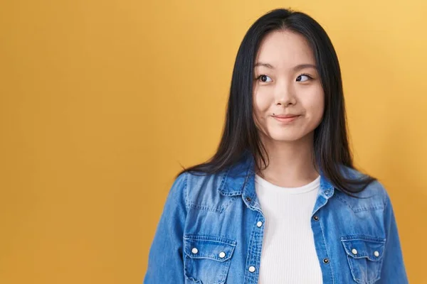 Jonge Aziatische Vrouw Staan Gele Achtergrond Glimlachen Kijken Naar Kant — Stockfoto