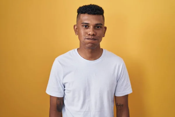 Mladý Hispánec Stojící Nad Žlutým Pozadím Čechrající Tváře Legrační Tváří — Stock fotografie