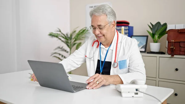 Mężczyzna Średnim Wieku Siwymi Włosami Lekarz Używający Laptopa Pracujący Klinice — Zdjęcie stockowe