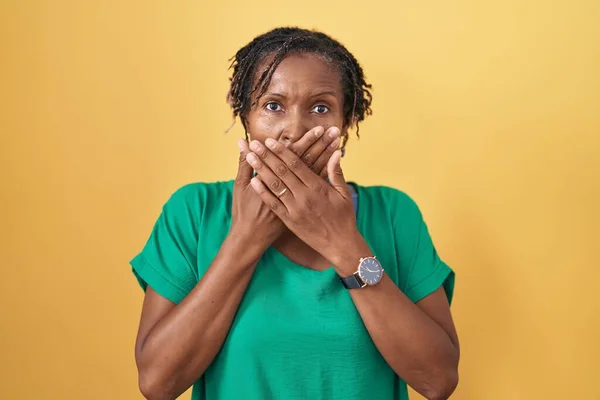 Mulher Africana Com Dreadlocks Sobre Fundo Amarelo Chocado Cobrindo Boca — Fotografia de Stock