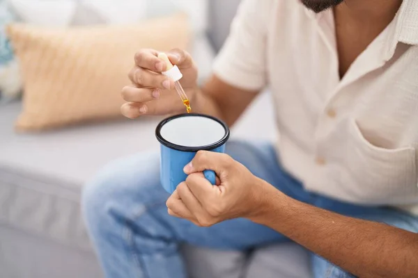 Junger Araber Gießt Flüssigkeit Auf Kaffee Sitzt Hause Auf Sofa — Stockfoto