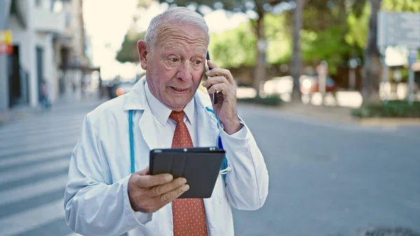 Senior Γκριζομάλλης Γιατρός Άνθρωπος Χρησιμοποιώντας Touchpad Μιλάμε Στο Smartphone Στο — Φωτογραφία Αρχείου