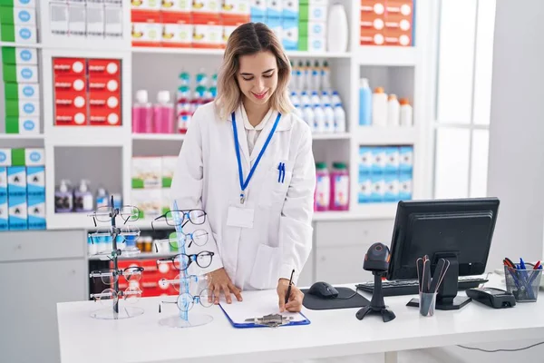 Young Woman Pharmacist Smiling Confident Writing Document Pharmacy — Foto Stock