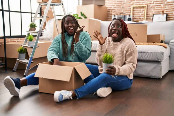 Twee Afrikaanse Vrouwen Verhuizen Naar Een Nieuw Huis Vloer Overwinning — Stockfoto
