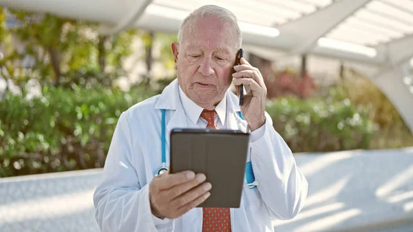 Senior Médico Hombre Pelo Gris Usando Touchpad Hablando Teléfono Inteligente —  Fotos de Stock