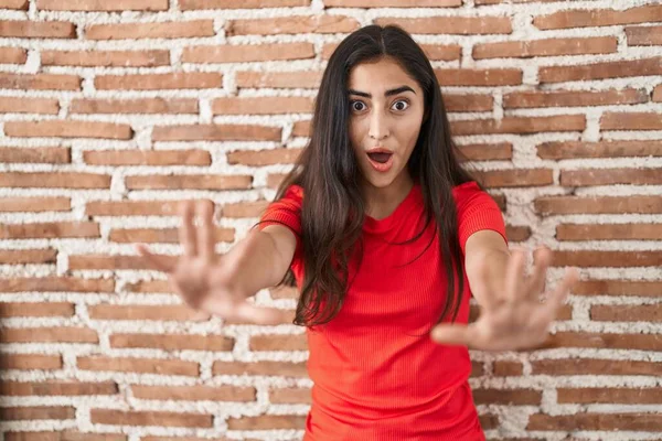 年轻的少女站在砖墙外 用手掌 愤怒和沮丧的表情做着停下来的手势 — 图库照片