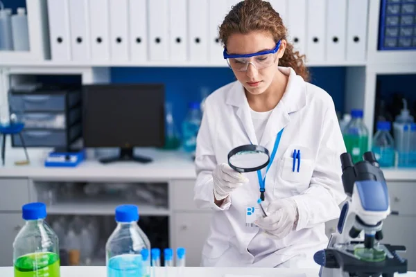 年轻美丽的惊慌失措的女科学家在实验室里看着装有百叶窗的试管 — 图库照片
