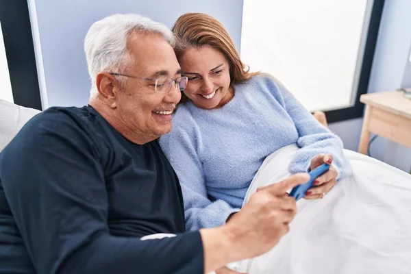 Μεσήλικας Άνδρας Και Γυναίκα Ζευγάρι Που Χρησιμοποιούν Smartphone Ξαπλωμένο Στο — Φωτογραφία Αρχείου