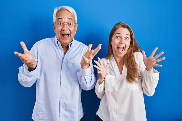 Couple Hispanique Moyen Age Debout Sur Fond Bleu Célébrant Fou — Photo