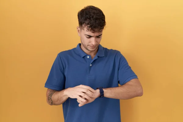 Young Hispanic Man Standing Yellow Background Checking Time Wrist Watch — Foto Stock