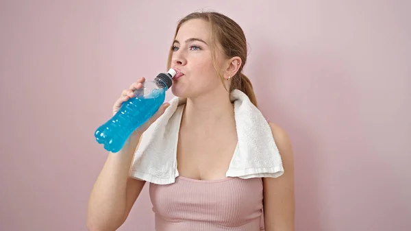 Młoda Blondynka Ubrana Strój Sportowy Pijąca Energetyczny Napój Odizolowanym Różowym — Zdjęcie stockowe