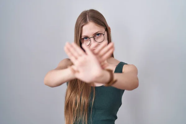 白い背景の拒絶表現の上に立つ若い白人女性腕と手のひらを横断負の記号を行う 怒っている顔 — ストック写真