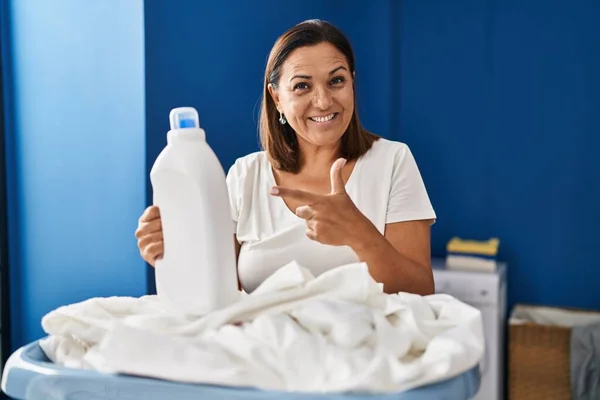 Middle Age Hispanic Woman Doing Laundry Holding Detergent Bottle Smiling —  Fotos de Stock