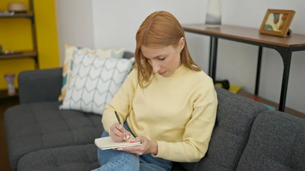 Mujer Rubia Joven Escribiendo Cuaderno Sentado Sofá Casa — Foto de Stock