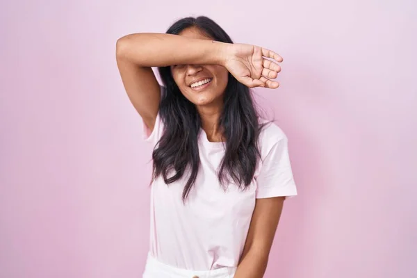 ピンクの背景に立っている若いヒスパニック系の女性は陽気で面白い笑顔で目をカバーしています 視覚障害の概念 — ストック写真