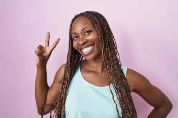 Mujer Afroamericana Pie Sobre Fondo Rosa Sonriendo Mirando Cámara Mostrando —  Fotos de Stock
