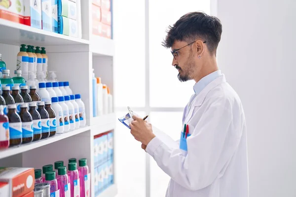 Young Hispanic Man Pharmacist Smiling Confident Writing Document Pharmacy — Stock Photo, Image