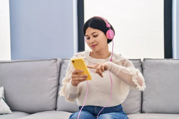 Young Chinese Woman Listening Music Sitting Sofa Home — Stockfoto