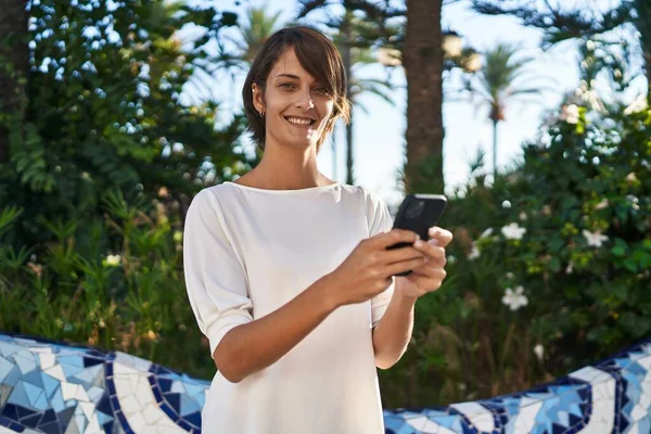 Parkta Akıllı Telefon Kullanarak Gülümseyen Güzel Bir Spanyol Kadın — Stok fotoğraf