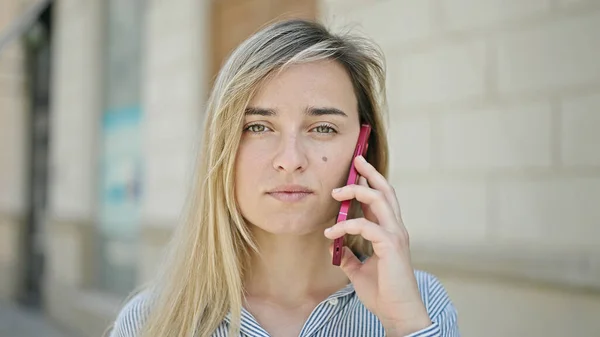 Young Blonde Woman Talking Smartphone Serious Expression Street — Fotografia de Stock