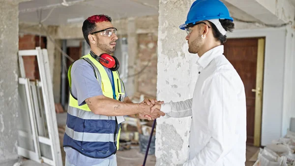两名建筑商和建筑师在建筑工地轻松自在地握手 — 图库照片