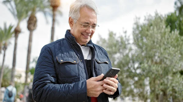 Medelålders Man Med Grått Hår Med Smartphone Ler Mot Park — Stockfoto