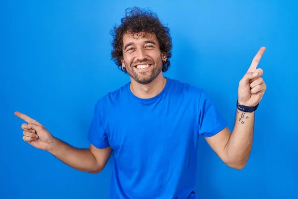Hispanic Young Man Standing Blue Background Smiling Confident Pointing Fingers — Stockfoto