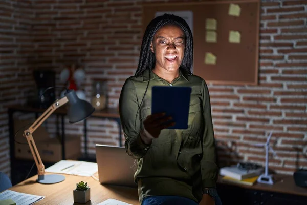 Junge Afroamerikanerin Mit Zöpfen Die Nachts Büro Arbeiten Und Zwinkernd — Stockfoto