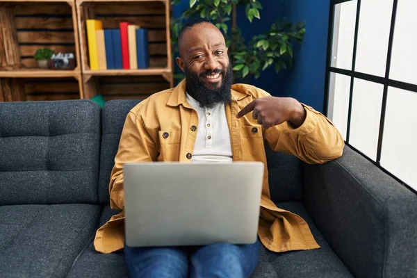 Afroamerikansk Man Använder Laptop Hemma Sitter Soffan Pekar Finger Till — Stockfoto