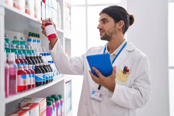 Young Hispanic Man Pharmacist Using Touchpad Holding Medication Bottle Pharmacy —  Fotos de Stock