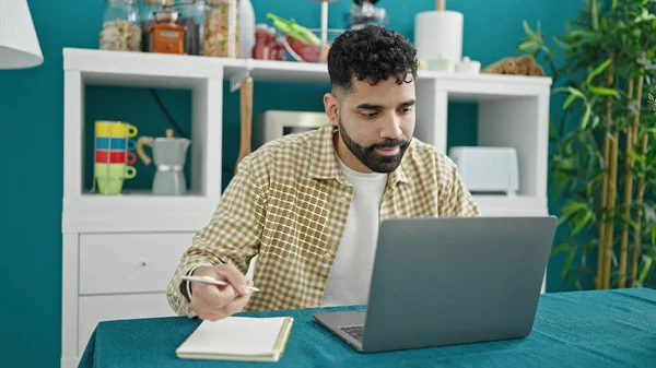 Jovem Hispânico Usando Laptop Escrevendo Notas Sala Jantar — Fotografia de Stock