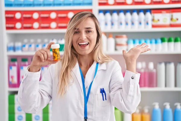 Mladá Blondýnka Pracující Lékárně Držení Pilulky Slaví Vítězství Šťastným Úsměvem — Stock fotografie