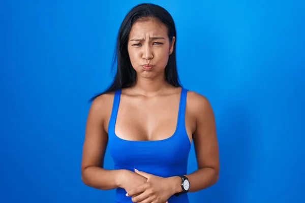 Mujer Hispana Pie Sobre Fondo Azul Hinchando Mejillas Con Cara —  Fotos de Stock