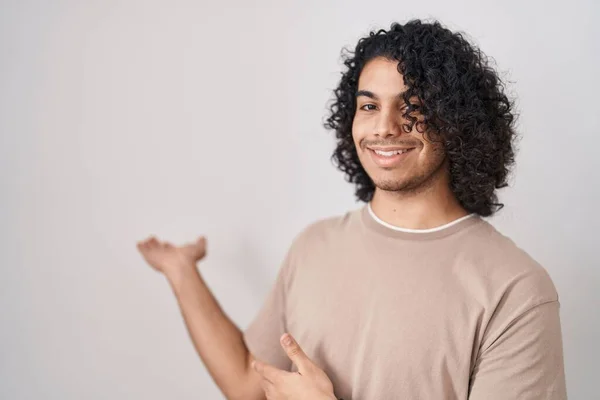 Hispanic Man Curly Hair Standing White Background Inviting Enter Smiling — Stock Photo, Image