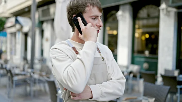 年轻的高加索人侍者在咖啡店的阳台上用智能手机交谈 — 图库照片