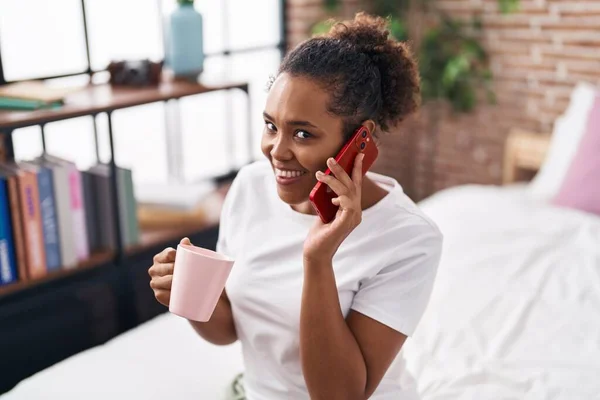 Αφροαμερικανή Γυναίκα Που Μιλάει Στο Smartphone Πίνοντας Καφέ Στο Υπνοδωμάτιο — Φωτογραφία Αρχείου